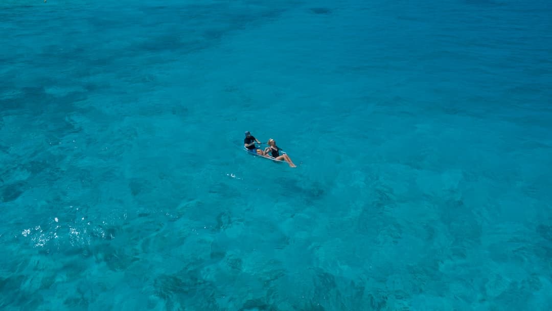 A kayaker is floating on the turquoise ocean. - Photo by Max Zaharenkov on Unsplash