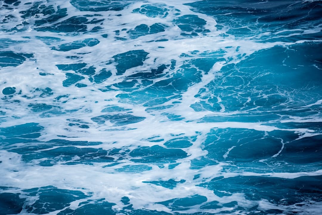 Overhead view of turbulent ocean water with white foam and swirling waves characteristic of rough Southern Ocean conditions. - Photo by James Eades on Unsplash