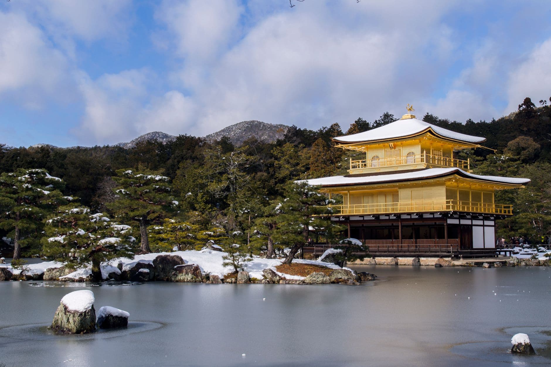 The Golden Pavilion (Kinkaku-ji) temple in Kyoto, Japan, photographed in winter with snow on the surrounding landscape, reflecting in the calm pond before it. - Photo by Andrey Grushnikov on Pexels