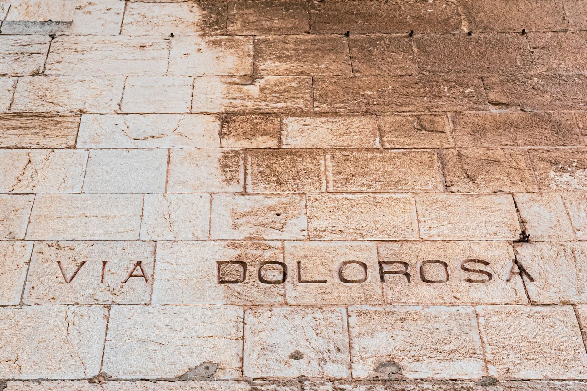 Close-up photograph of ancient Roman stone paving with Latin inscription carved into the blocks. - Photo by Anat Landa on Pexels